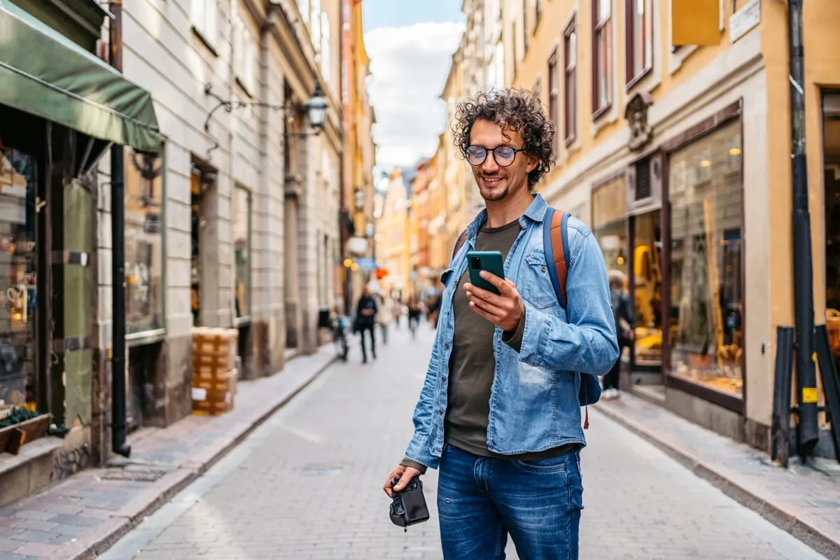 Photographer checking his phone on a European street