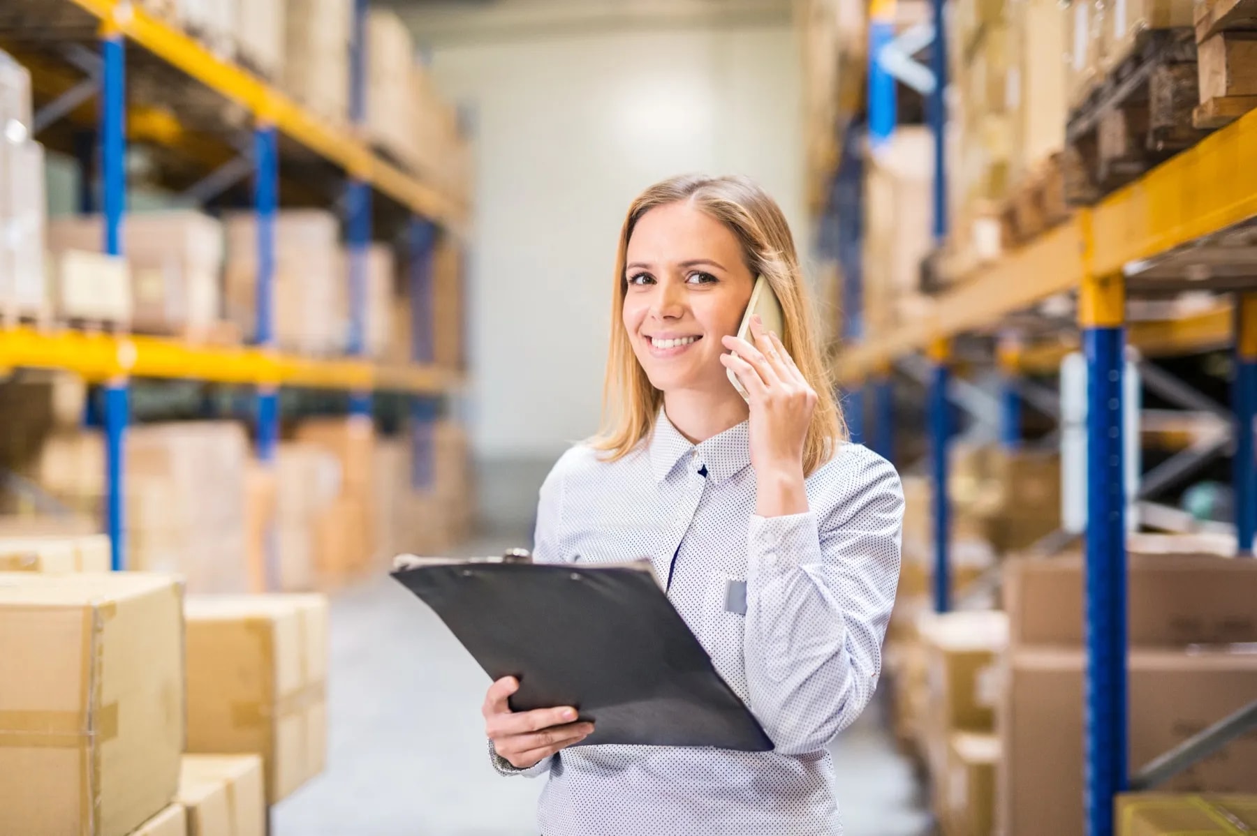 Warehouse manager checking orders and taking a business call