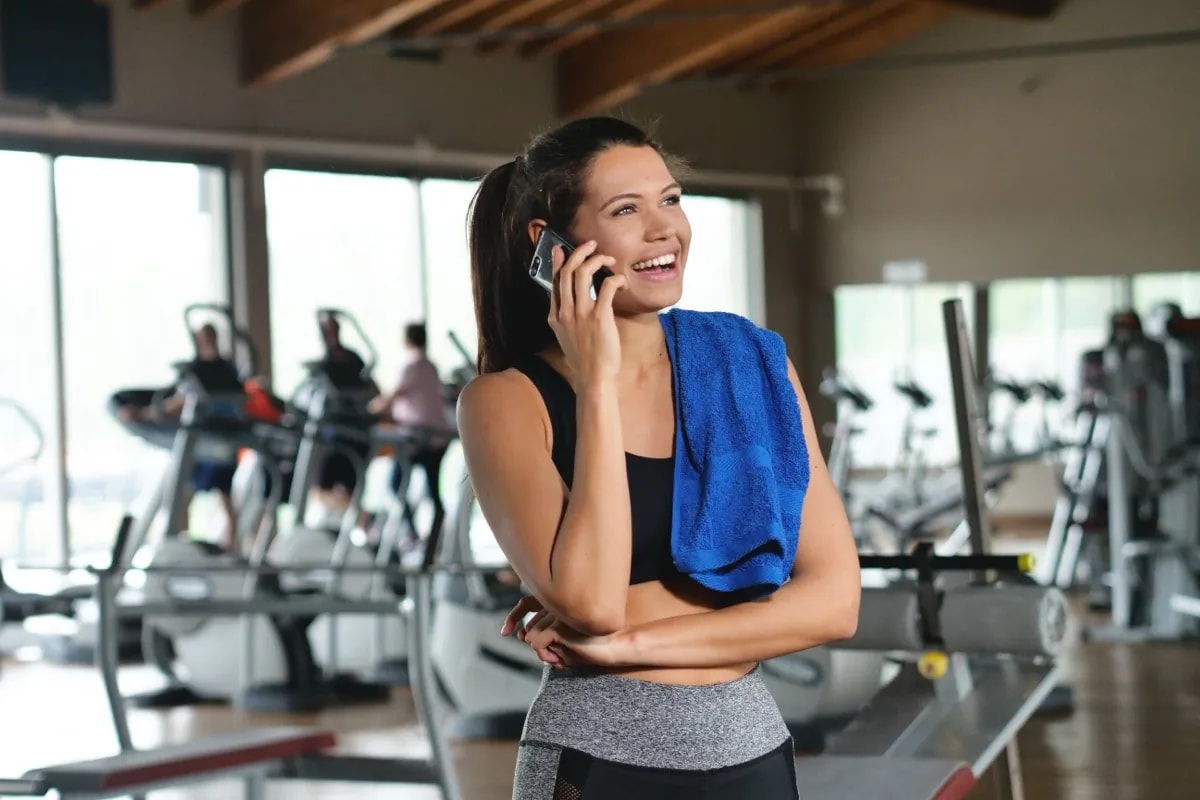 Personal trainer taking a work call in a gym